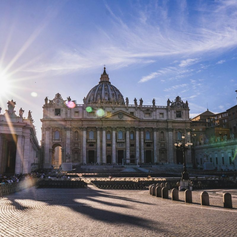 Stunning view of St. Peter's Basilica with sun rays, perfect for tourism and architecture themes.