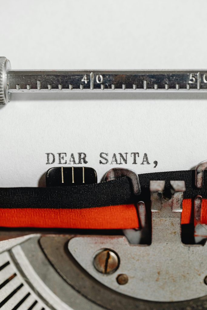 Close-up of a vintage typewriter typing 'Dear Santa,' on paper, capturing a festive and nostalgic holiday scene.