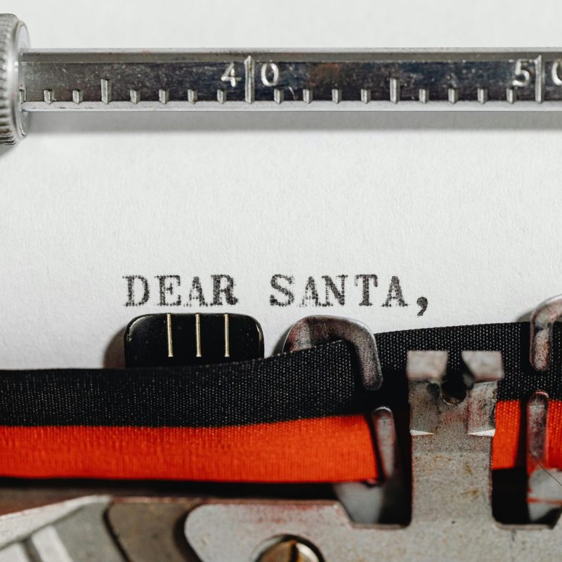 Close-up of a vintage typewriter typing 'Dear Santa,' on paper, capturing a festive and nostalgic holiday scene.